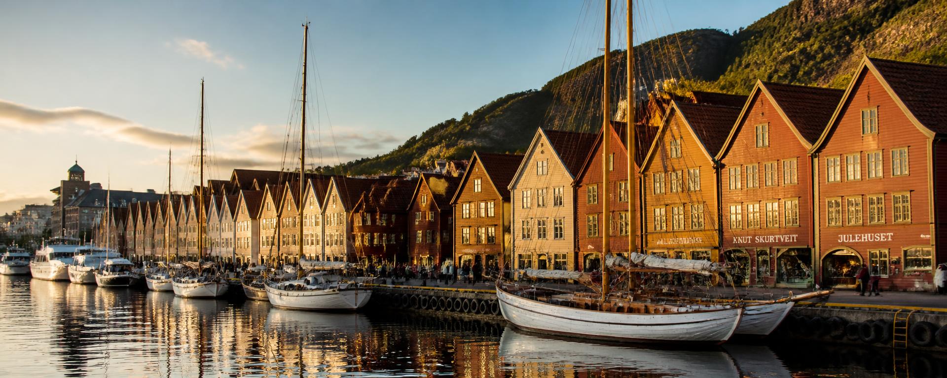 Vågen i Bergen med Bryggens trehusrekke i gyllent kveldslys.